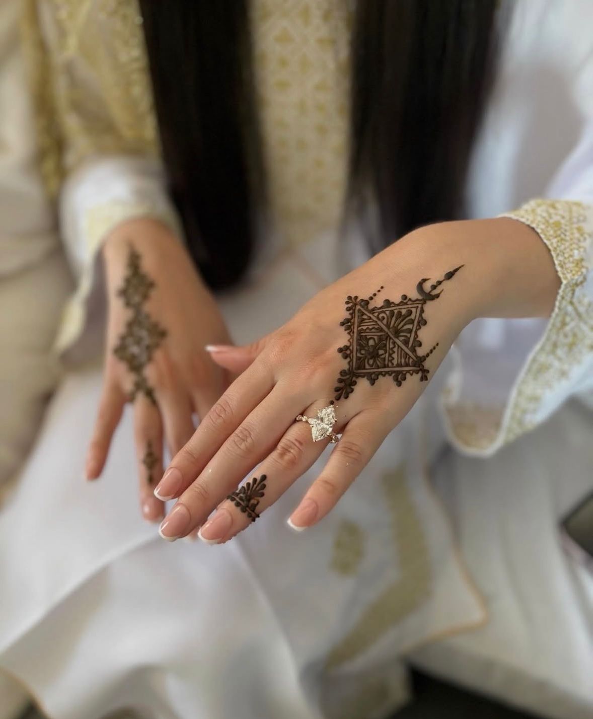 Minimalistisch hennadesign met ruit en maan op de handrug