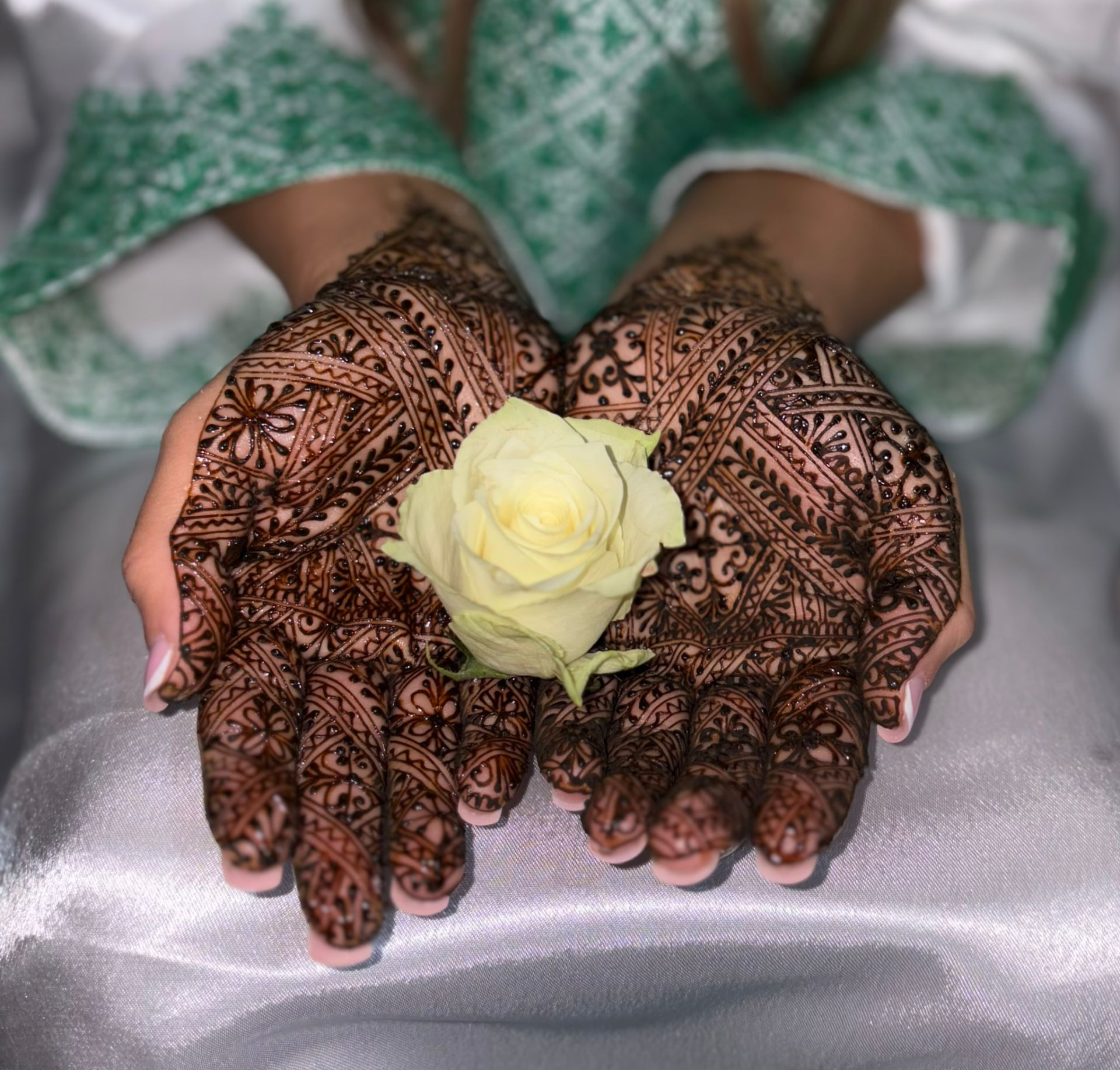 Bruid met Fessi-stijl henna op beide handen, met een witte roos